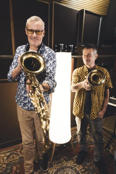 Deux musiciens d’Os Pariocas posent avec leurs instruments à vent dans le studio Midilive.